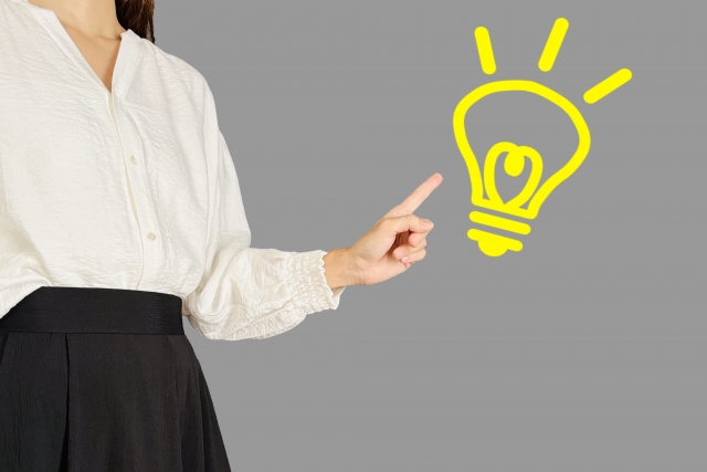 左に立つ女性が人差し指で電球のアニメーションを指している
